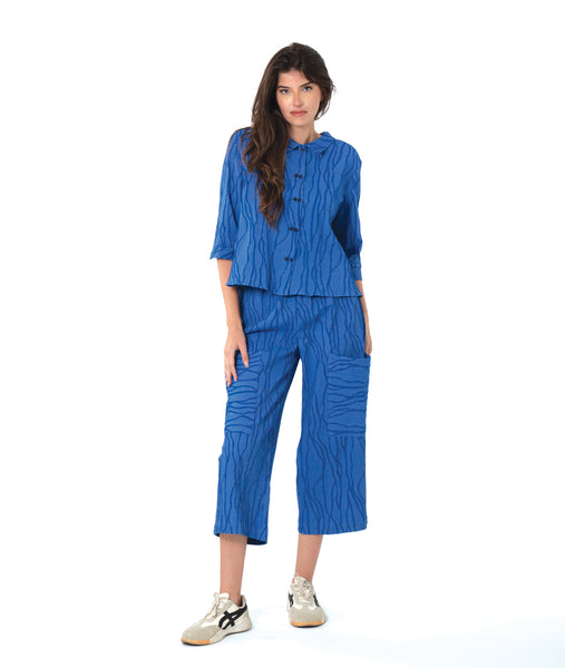 model in a blue button down blouse with a twin button detail and 3/4 sleeves. worn with a matching straight leg cargo pant