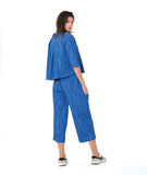 model in a blue button down blouse with a twin button detail and 3/4 sleeves. worn with a matching straight leg cargo pant