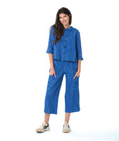 model in a blue button down blouse with a twin button detail and 3/4 sleeves. worn with a matching straight leg cargo pant