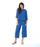 model in a blue button down blouse with a twin button detail and 3/4 sleeves. worn with a matching straight leg cargo pant