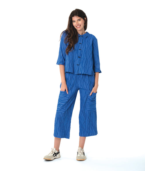 model in a blue button down blouse with a twin button detail and 3/4 sleeves. worn with a matching straight leg cargo pant
