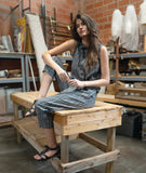 model in a grey sleeveless top with a twin button detail, worn with a matching slim crop pant