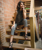 model in a grey sleeveless top with a twin button detail, worn with a matching slim crop pant