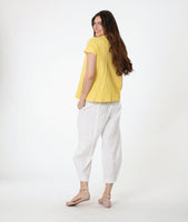 model in a yellow button down blouse with cap sleeves. worn with a white barrel leg pant 