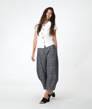 model in a white button down blouse with cap sleeves. worn with a grey barrel leg pant 