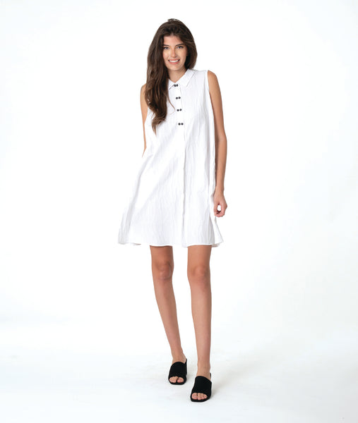 Woman wearing a white sleeveless shirt dress with  a black twin button detailing