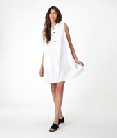 Woman wearing a white sleeveless shirt dress with  a black twin button detailing