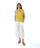 model in a white pant with a checkered yellow and grey print button down sleeveless blouse with a boxy body and a twin button detail