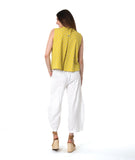model in a white pant with a checkered yellow and grey print button down sleeveless blouse with a boxy body and a twin button detail
