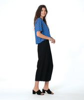 model in a black pant with a checkered blue and grey print button down blouse with short sleeves and a cropped body