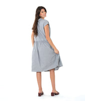 model in a grey and white pinstripe shirtdress with a gathered skirt detailng and hip pockets