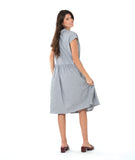 model in a grey and white pinstripe shirtdress with a gathered skirt detailng and hip pockets