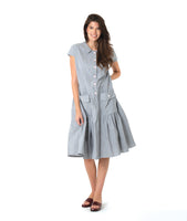 model in a grey and white pinstripe shirtdress with a gathered skirt detailng and hip pockets