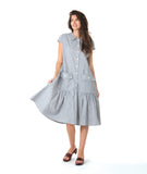 model in a grey and white pinstripe shirtdress with a gathered skirt detailng and hip pockets