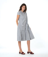 model in a grey and white pinstripe shirtdress with a gathered skirt detailng and hip pockets