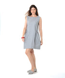 model in a sleeveless pinstripe shift dress with princess sleeves and a squared neckline. pockets are set into the seams and have a red embroidery detail