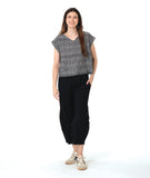 model in a boxy plaid black and white top with a black wide leg pant with a tapered ankle
