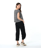 model in a boxy plaid black and white top with a black wide leg pant with a tapered ankle
