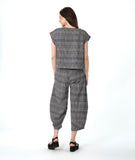 model in a boxy plaid black and white top with a matching wide leg pant with a tapered ankle and oversized exterior pockets