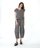 model in a boxy plaid black and white top with a matching wide leg pant with a tapered ankle and oversized exterior pockets
