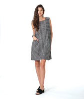model in a sleeveless black and white plaid shift dress with princess seams, a squared neckline and hip pockets
