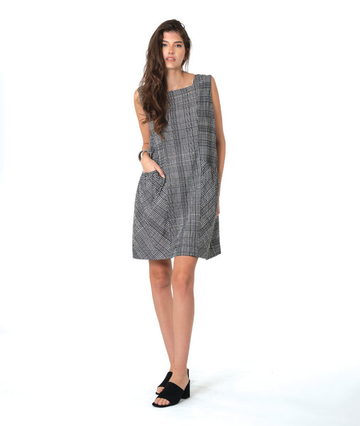 model in a sleeveless black and white plaid shift dress with princess seams, a squared neckline and hip pockets