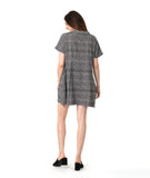 model in a black and white plaid pullover dress with short raglan sleeves, a standing portrait collar, and shaping darts along the waist