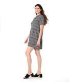 model in a black and white plaid pullover dress with short raglan sleeves, a standing portrait collar, and shaping darts along the waist
