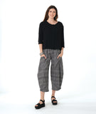model in a 3/4 sleeve black pullover top with a black and white plaid pant with a wide leg, tapered ankle, and oversized pockets