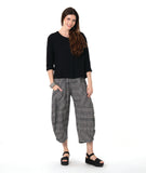 model in a 3/4 sleeve black pullover top with a black and white plaid pant with a wide leg, tapered ankle, and oversized pockets