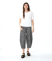 model in a boxy white tee with a wide leg plaid black and white pant