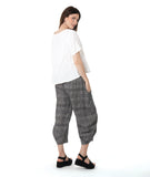 model in a boxy white tee with a wide leg plaid black and white pant