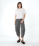 model in a boxy white tee with a wide leg plaid black and white pant