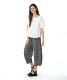 model in a boxy white tee with a wide leg plaid black and white pant