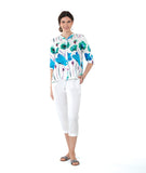 model in a white crop pant with a white button down blouse with a vibrant floral print. top has 3/4 sleeves and a mandarin style collar