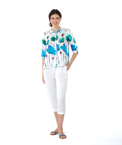 model in a white crop pant with a white button down blouse with a vibrant floral print. top has 3/4 sleeves and a mandarin style collar