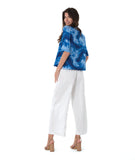 model in a wide leg white pant, worn with a multi tonal blue print button down blouse