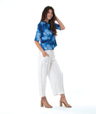 model in a wide leg white pant, worn with a multi tonal blue print button down blouse