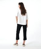 model in a slim black pant, worn with a white pullover top with a wide, flat collar