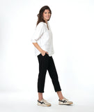 model in a slim black pant, worn with a white pullover top with a wide, flat collar