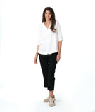 model in a slim black pant, worn with a white pullover top with a wide, flat collar