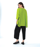 model in a slim black pant, worn with a lime color pullover blouse with a low back hem and a vneck