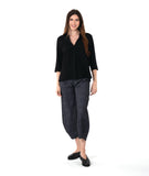 model in a black and grey stripe pant, worn with a black pullover top with an open, flat collar