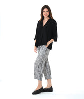model in a black and white stripe pant, worn with a black pullover top with an open, flat collar