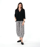 model in a black and white stripe pant, worn with a black pullover top with an open, flat collar