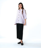 model in a wide leg black pant worn with a soft pink button down with a full body and extra large rounded pockets