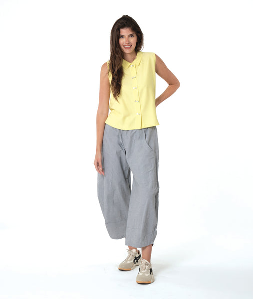 model in a grey and white pinstripe pant, worn with a soft yellow sleeveless button down blouse