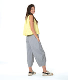 model in a grey and white pinstripe pant, worn with a soft yellow sleeveless button down blouse