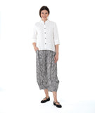 model in a black and white striped pant with a white button down blouse with a double collar