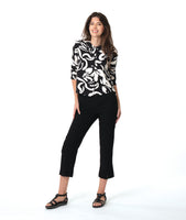 model in a slim black pant, worn with a black and white floral print button down blouse